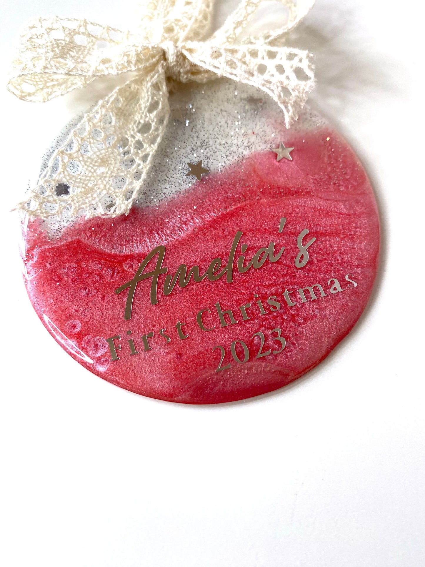Pink Baby First Christmas resin bauble with glittery gold top and twinkling gold stars, personalised with "1st Christmas" in silver lettering, hanging with beige lace ribbon and bow