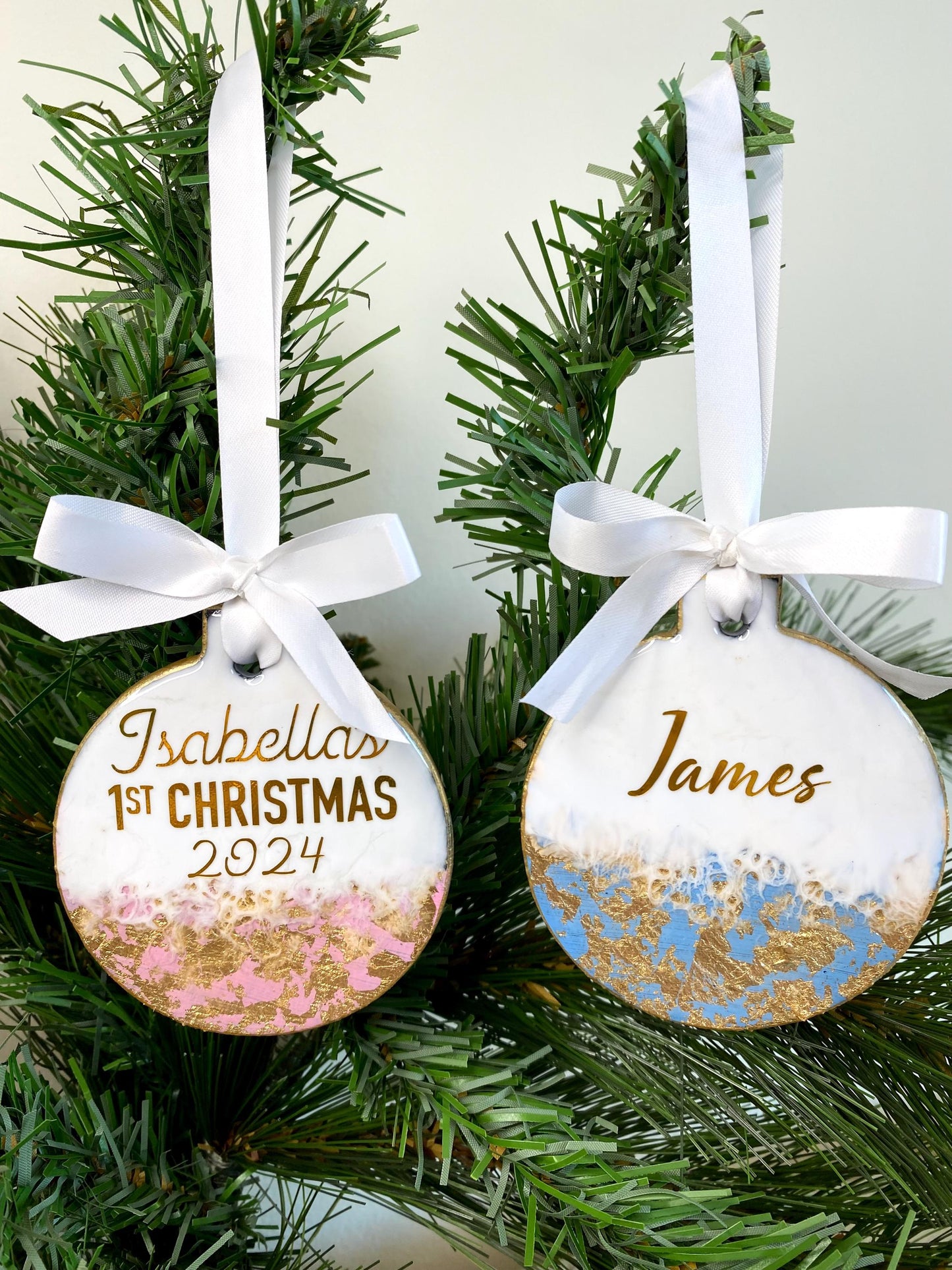 Blue and pink slate resin Baby’s First Christmas ornaments hanging on a decorated Christmas tree, personalised with name and First Christmas 2025 in gold, ready to display.