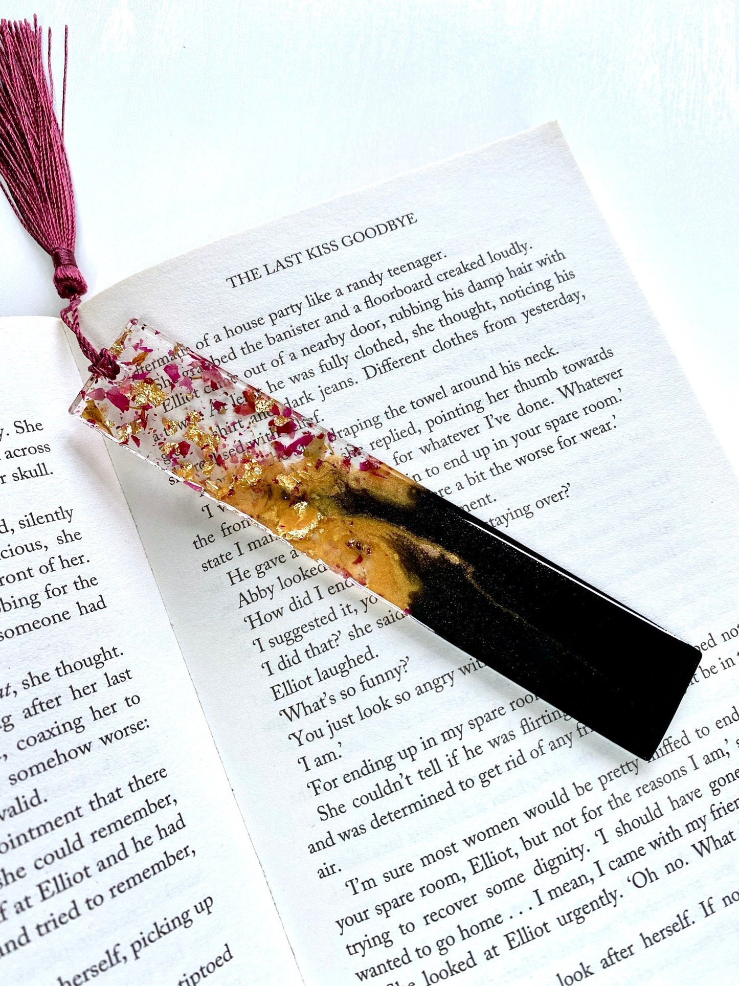 Decorative resin bookmark with floral elements shown on an open book