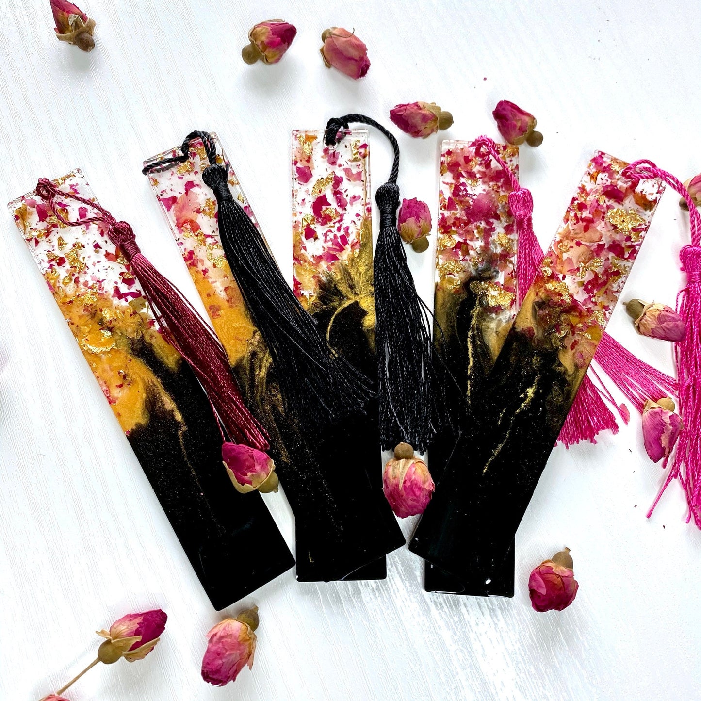 Five black and gold resin bookmarks with dried rose petals and matching tassels
