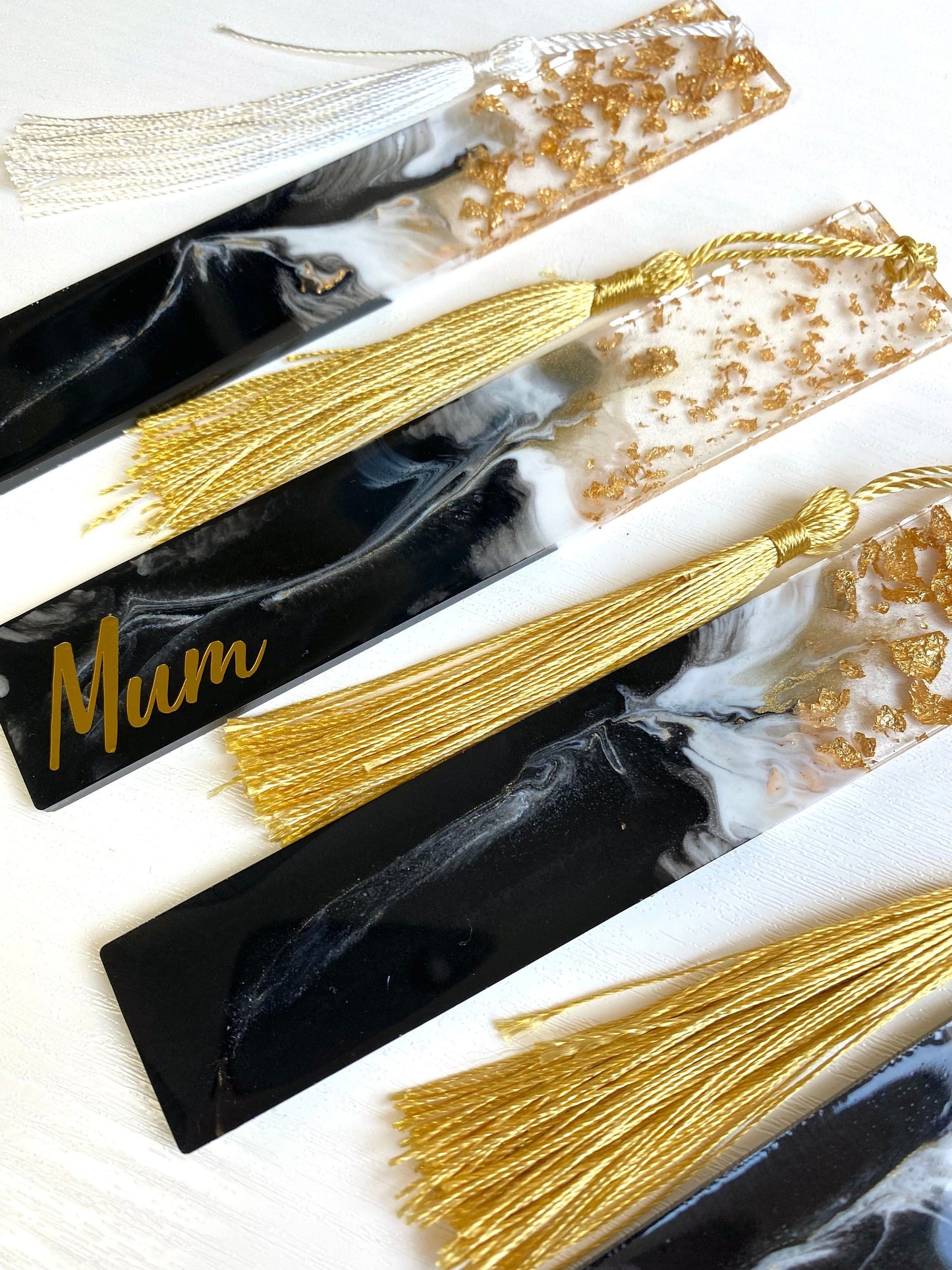 Four black resin bookmarks with gold leaf, two personalised with gold vinyl and two non-personalised, handmade bookmarks for readers or gifts