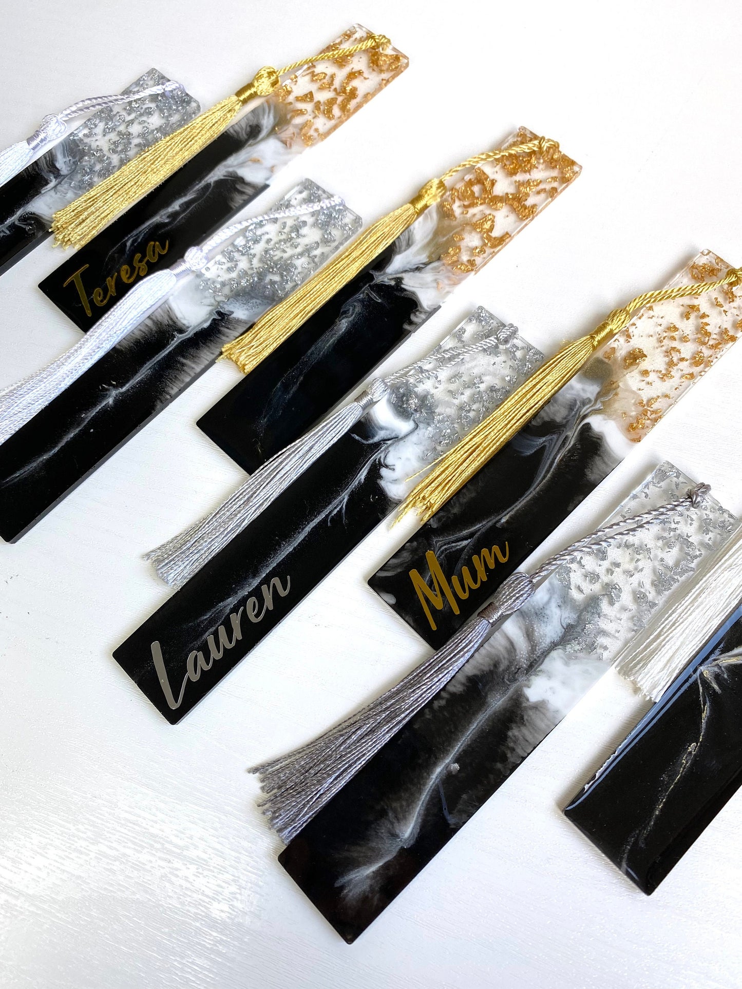 Close-up of eight black and white resin bookmarks with gold and silver leaf, including personalised and non-personalised options, showcasing handmade details, elegant bookmarks for readers or gifts