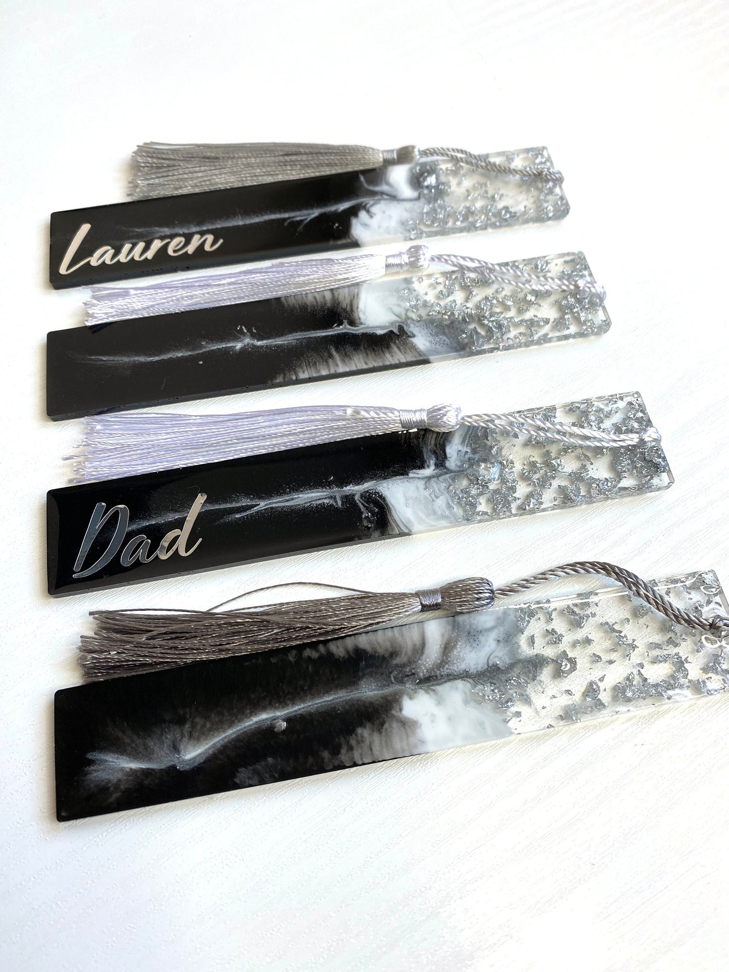 Four black and white resin bookmarks with silver leaf, two personalised with silver vinyl and two non-personalised, handmade bookmarks for readers or gifts