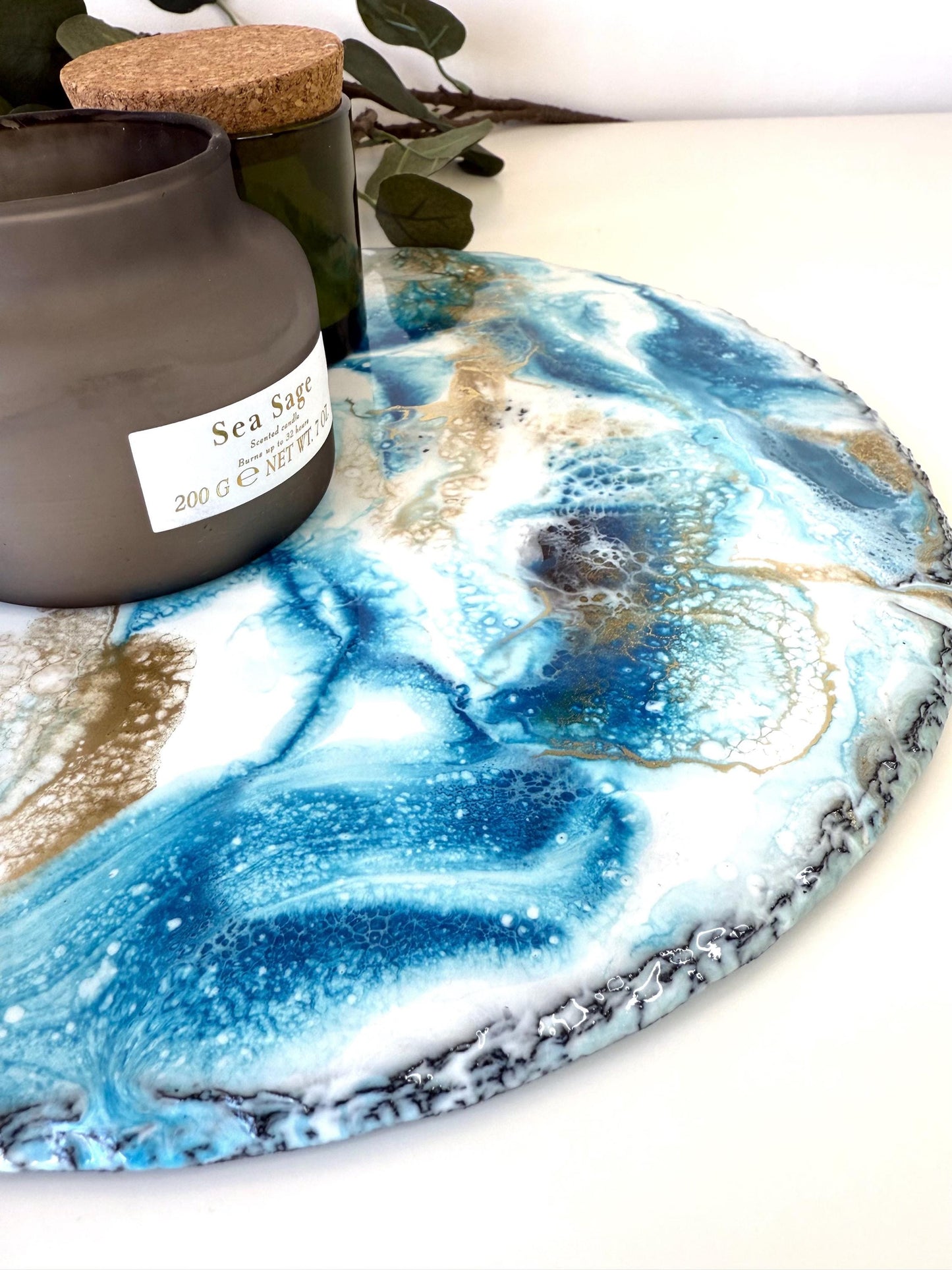 Close-up of handmade ocean resin tray with slate base, focusing on natural, unfinished edges, highlighting craftsmanship and unique coastal-inspired design