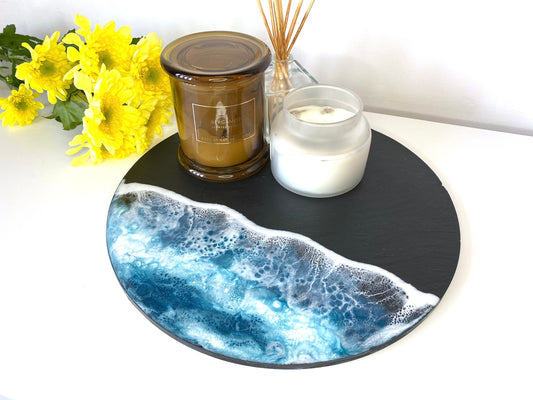 Handmade ocean resin charcuterie tray with slate base, styled with candles, coastal-inspired decorative serving and cheese board, flowers in the background, elegant home display