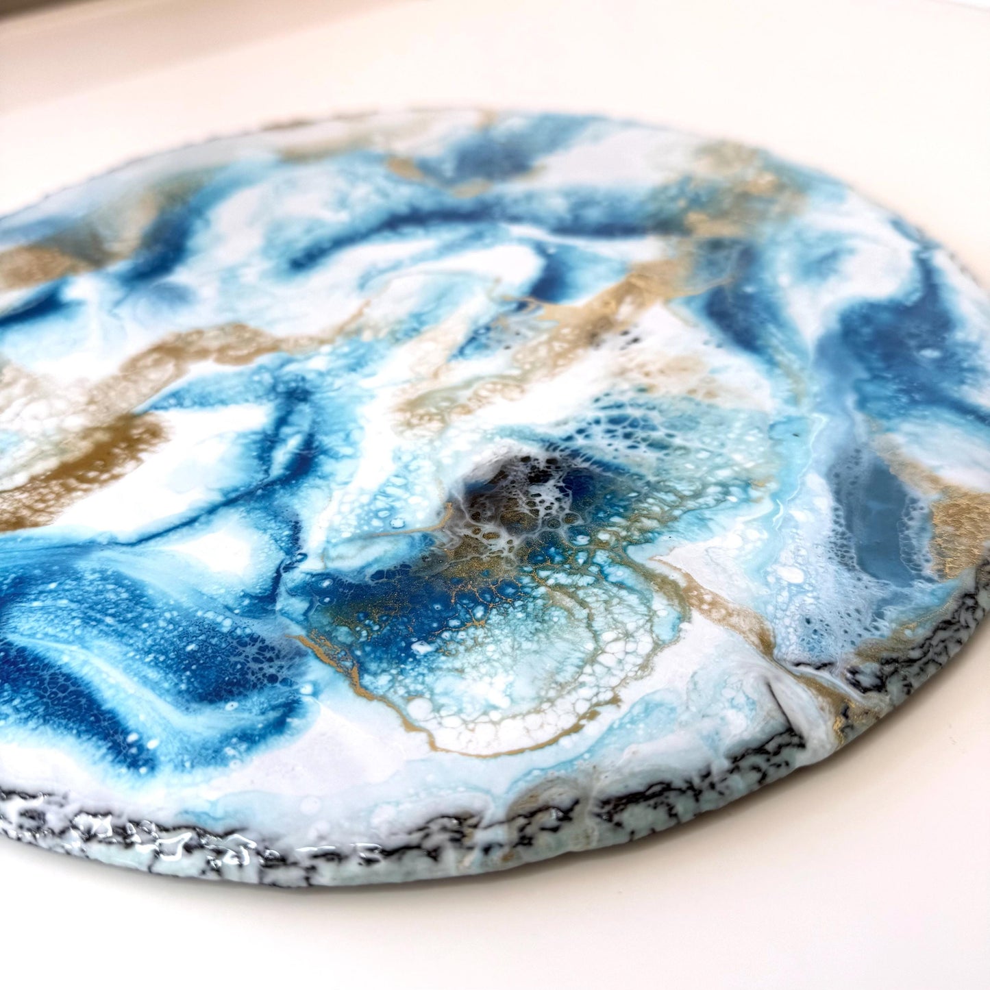 Close-up of handmade ocean resin tray with slate base, highlighting blue and white resin wave details, empty display showing coastal-inspired craftsmanship for home decor or serving.