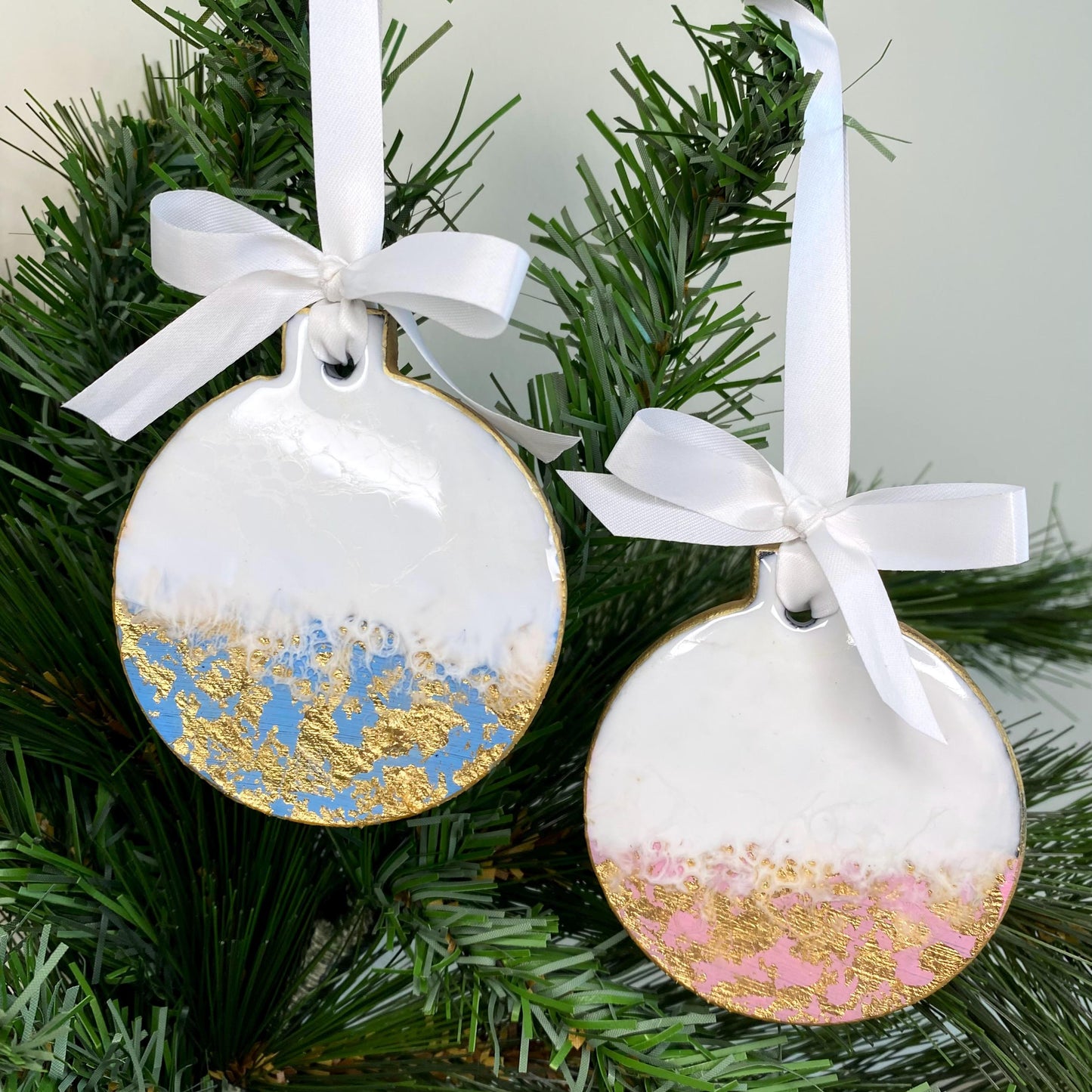 Pink and blue slate resin Christmas ornaments hanging on a Christmas tree, non-personalised, with gold leaf accents and white ribbons and bow