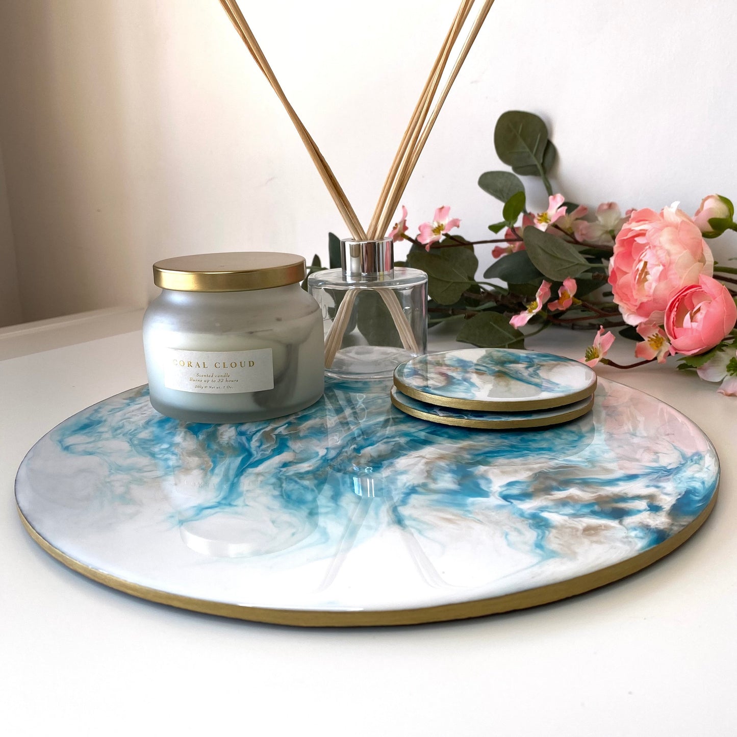 Close-up of handmade white and blue resin tray with slate base and matching coasters, highlighting hand-painted gold edges, large round coffee table and decorative tray for elegant home display or serving