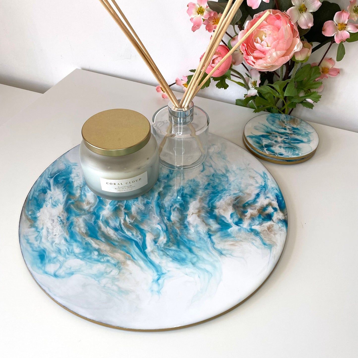 Handmade white and blue resin tray with slate base, large round coffee table and decorative tray, styled with candle and diffuser, set of two matching resin coasters displayed next to tray, elegant home décor for serving or display