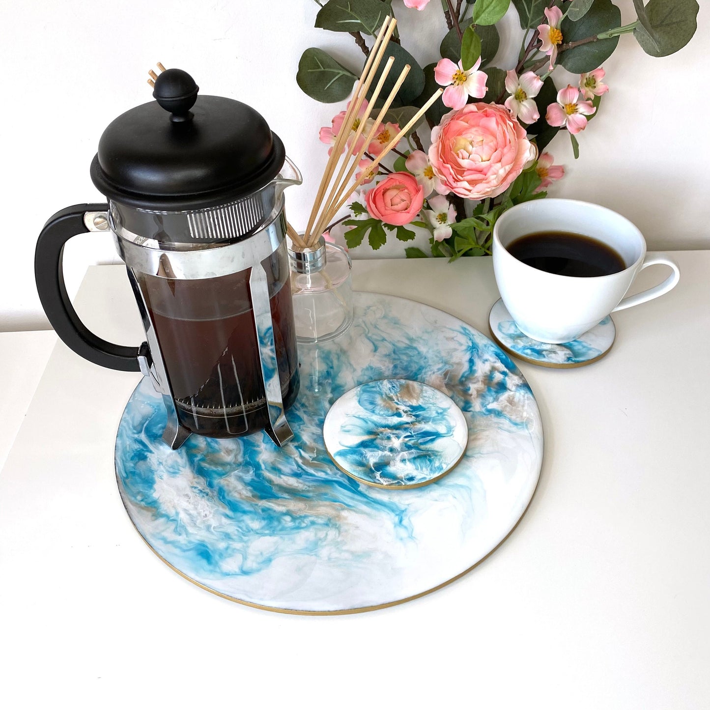 Handmade white and blue resin tray with slate base, large round coffee table and decorative tray, styled with filter coffee maker on tray, one matching resin coaster on tray, second coaster next to tray with coffee cup, elegant home display for serving or décor