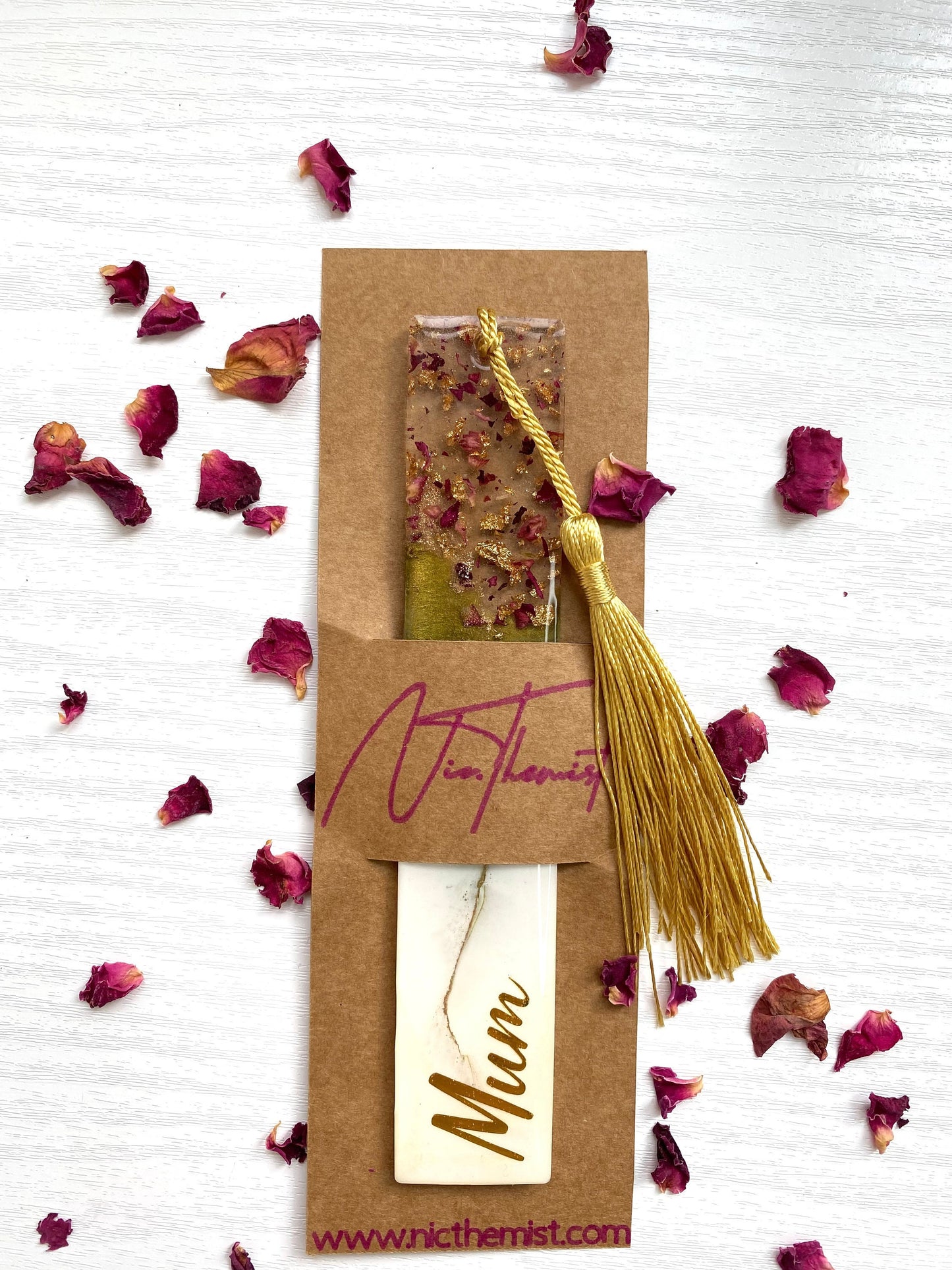White and green resin bookmark with dried roses and gold leaf, personalised, inside packaging sleeve with logo, featuring a gold tassel, handmade bookmark for readers or gifts.