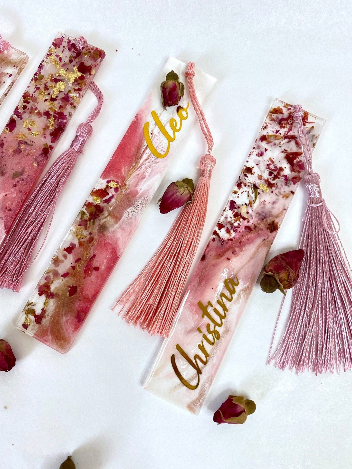 Close-up of white and pink resin bookmarks with dried roses and gold leaf, showing handmade details and variations including personalised and non-personalised options, elegant bookmarks for readers or gifts