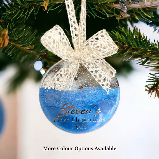 Blue Baby First Christmas resin bauble with glittery silver top and twinkling stars, personalised silver lettering, hanging with a beige lace ribbon and bow