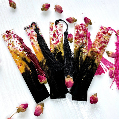 Five black and gold resin bookmarks with dried rose petals and matching tassels
