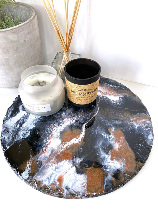 Handmade black and gold resin tray with slate base, large round coffee table and vanity tray, styled with candles and diffuser, pot in the background, elegant decorative tray for home display or serving.