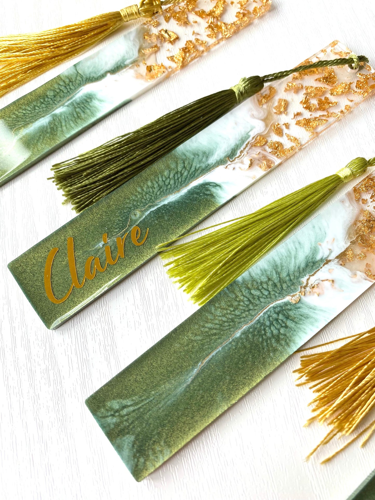 Close-up of the bottom of green resin bookmark with gold leaf, showing handmade details and colourful tassel, personalised and non-personalised options, elegant bookmark for readers or gifts