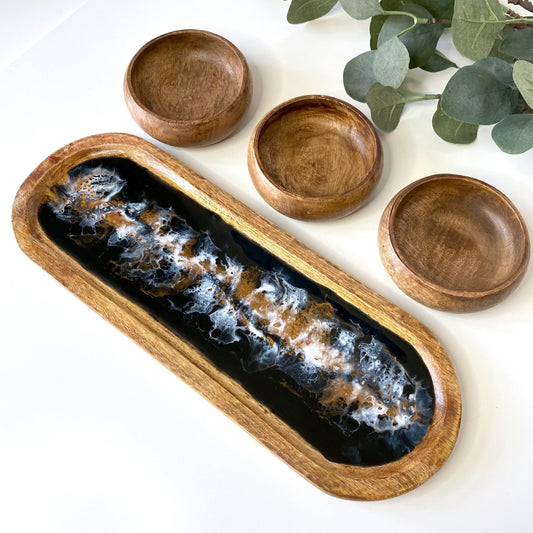 Large handcrafted wooden oval tray with swirling epoxy resin details, accompanied by three plain wooden bowls – perfect for charcuterie or home décor.