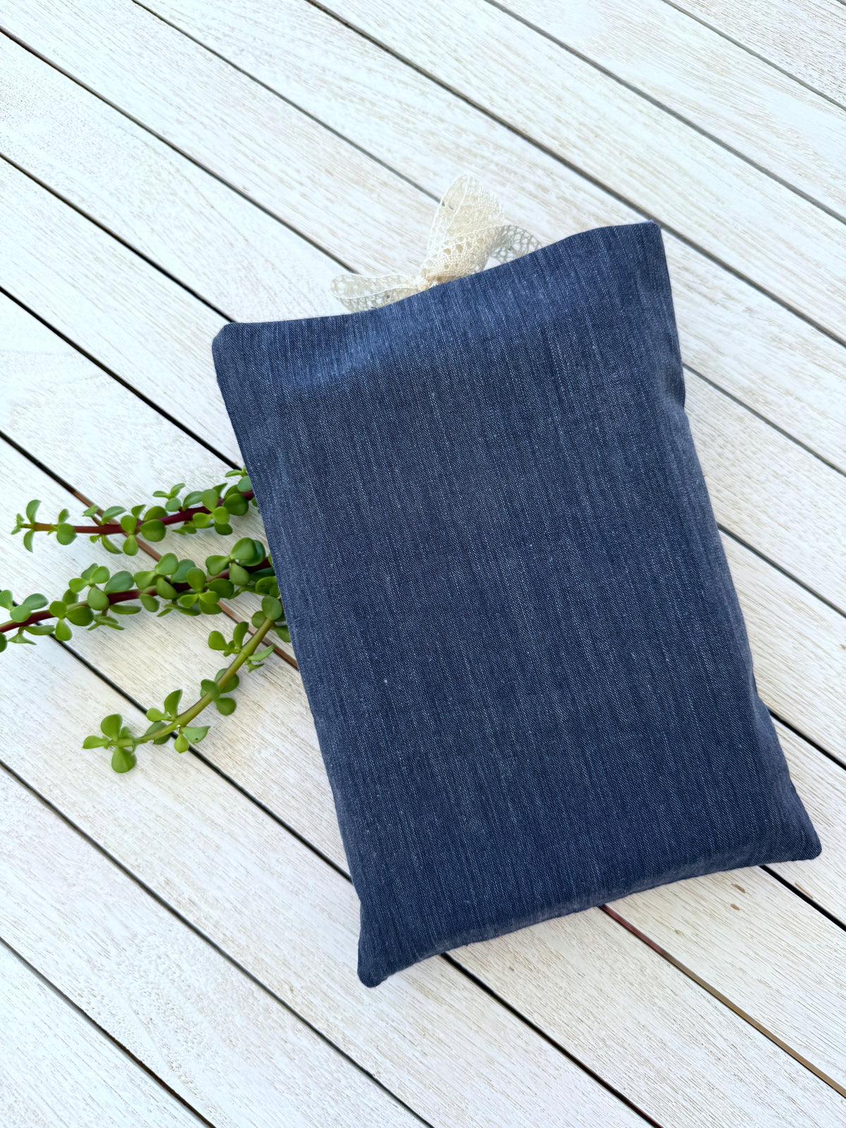 Back view of a handmade navy denim-look fabric book sleeve, showing its plain navy reverse side and rectangular shape.