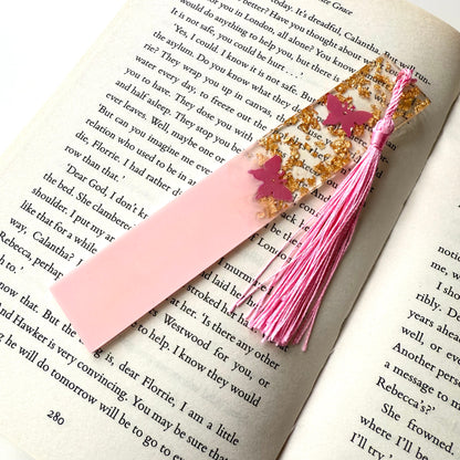 Non-personalised pink resin bookmark with butterfly design on an open book, featuring a matching tassel.