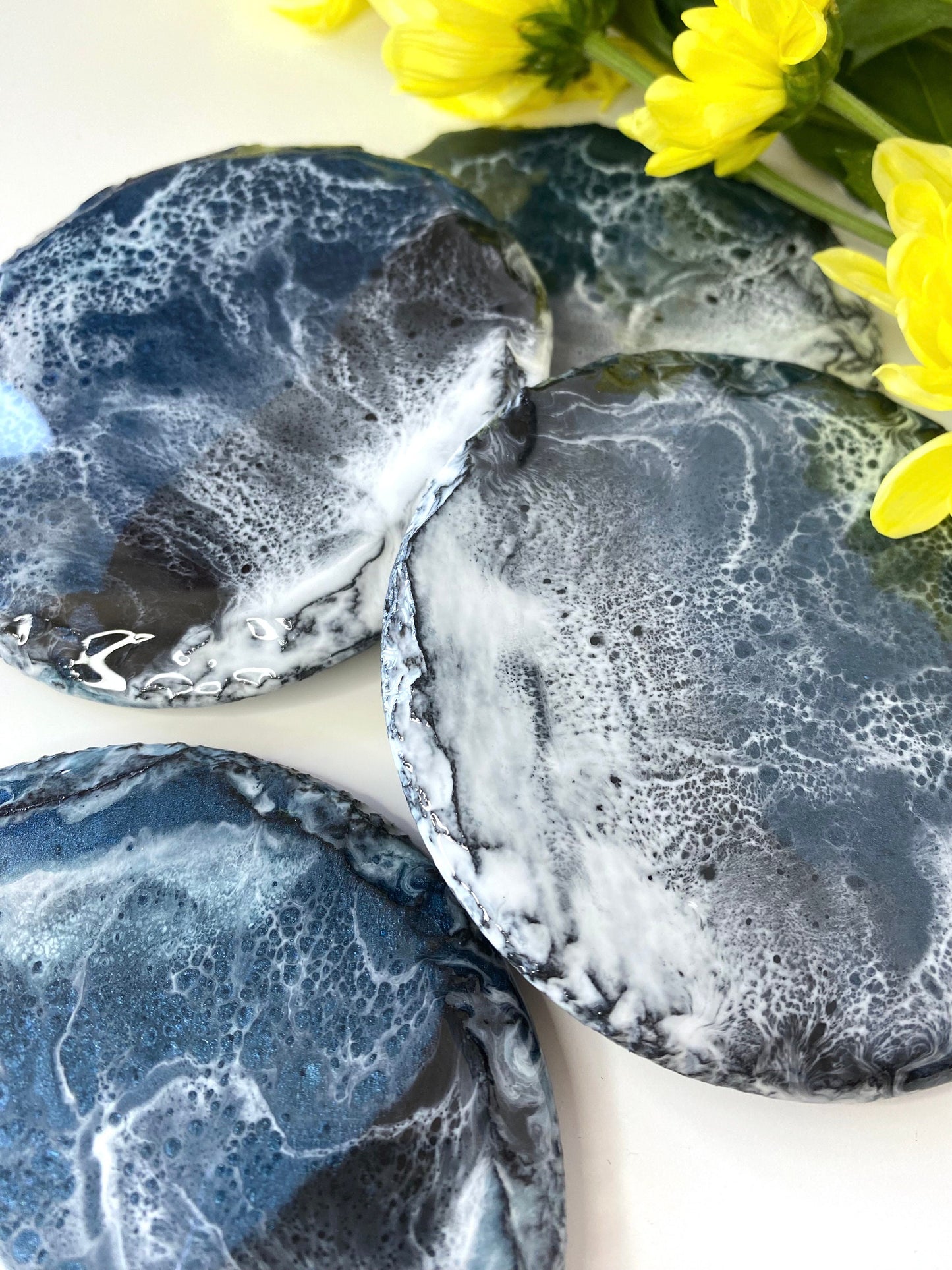 Close-up of four round resin art slate coasters, ocean-inspired design, highlighting intricate wave patterns and handmade craftsmanship, decorative coasters for home or gifts.