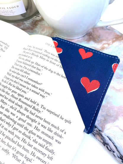 Personalised handmade fabric corner bookmark in Blue with Red Hearts design, placed on a book page – ideal gift for book lovers, teachers, and reading enthusiasts.