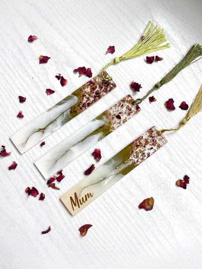 Three white and green resin bookmarks with dried roses and gold leaf, one personalised with gold vinyl and two non-personalised, each featuring a gold or green tassel, handmade bookmarks for readers or gifts.
