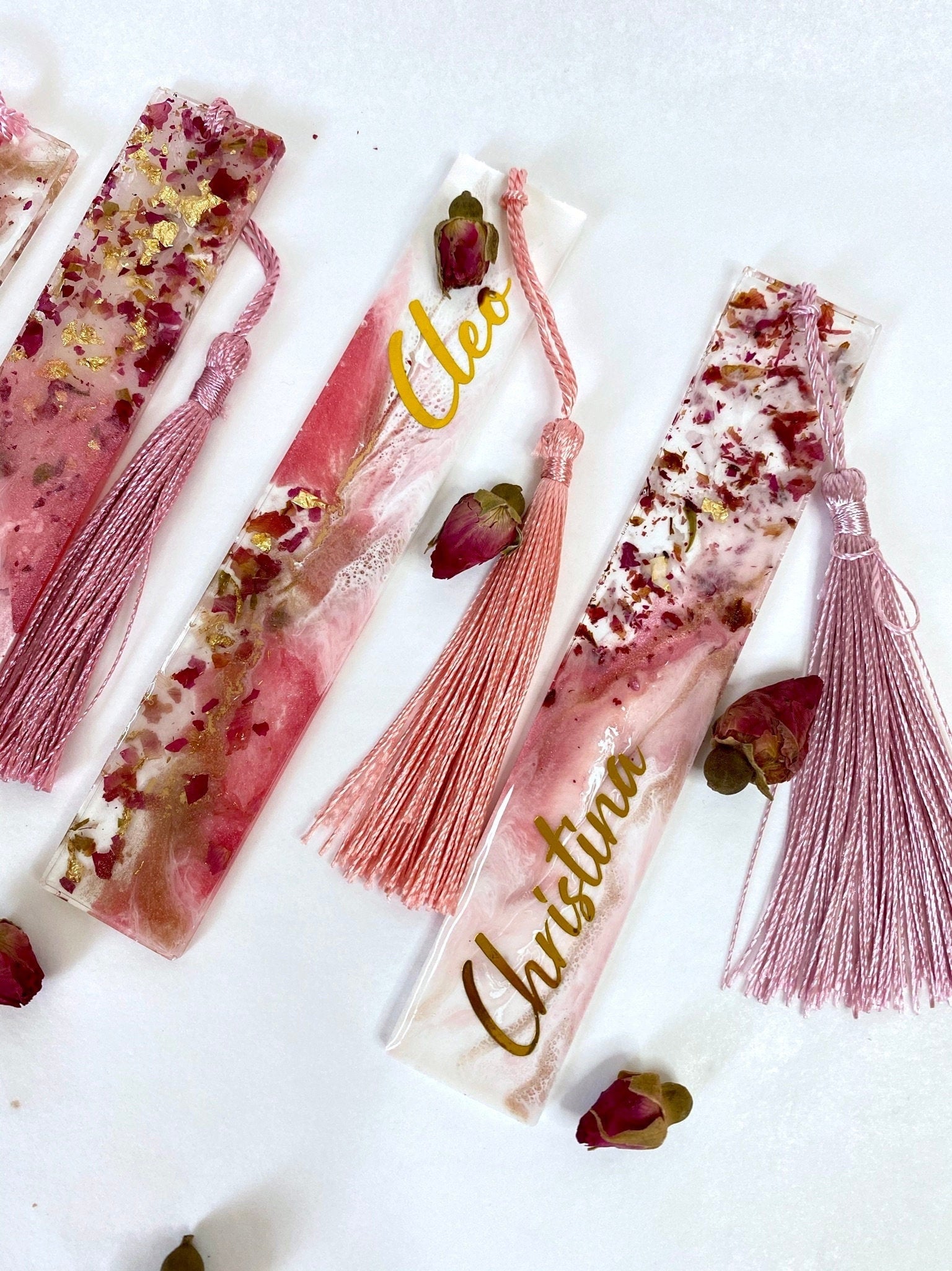 Close-up of white and pink resin bookmarks with dried roses and gold leaf, showing handmade details and variations including personalised and non-personalised options, elegant bookmarks for readers or gifts