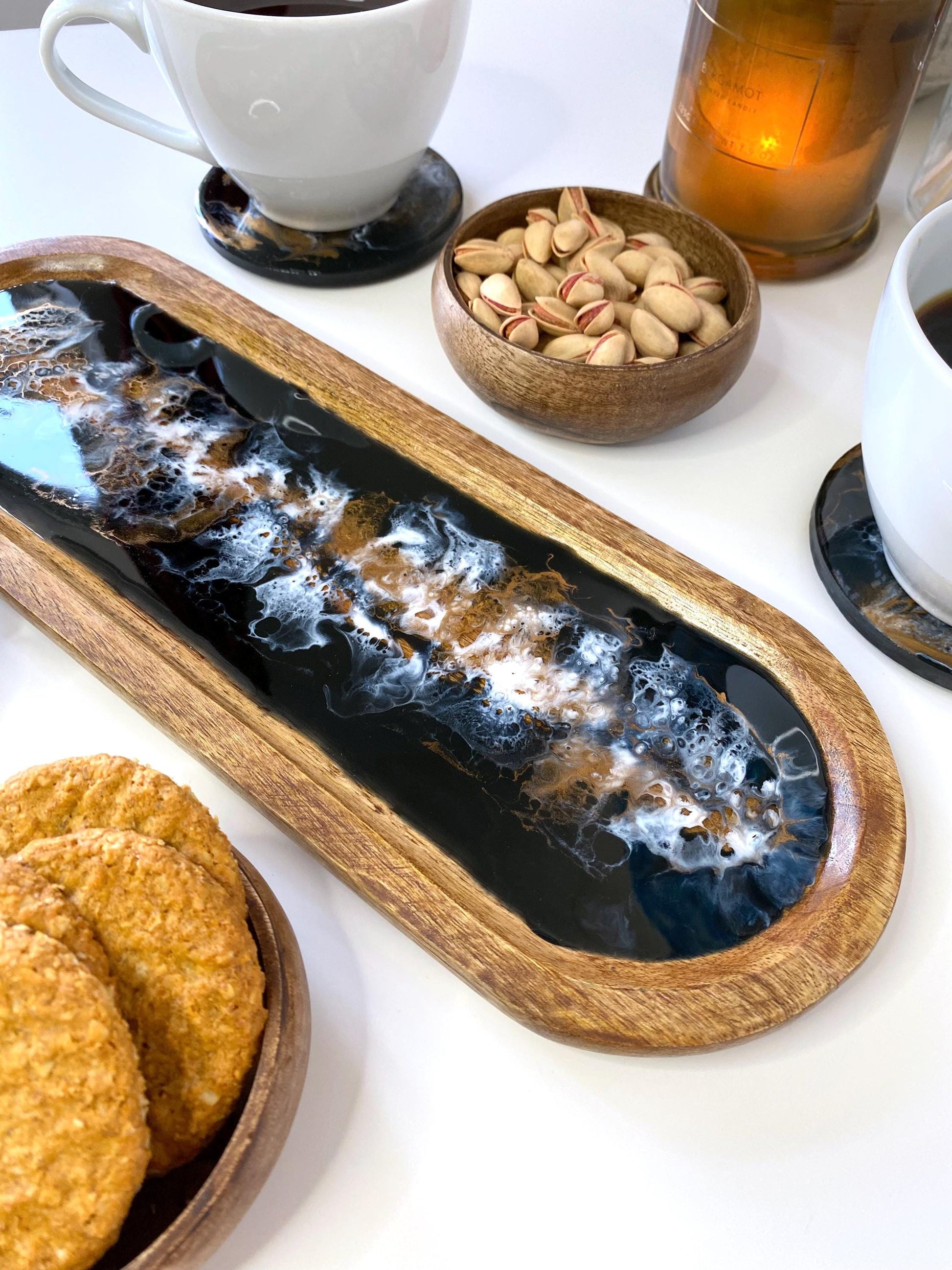 Close-up of large handcrafted wooden oval tray highlighting black, white, and bronze epoxy resin swirl details – unique, one-of-a-kind design for serving or home décor.